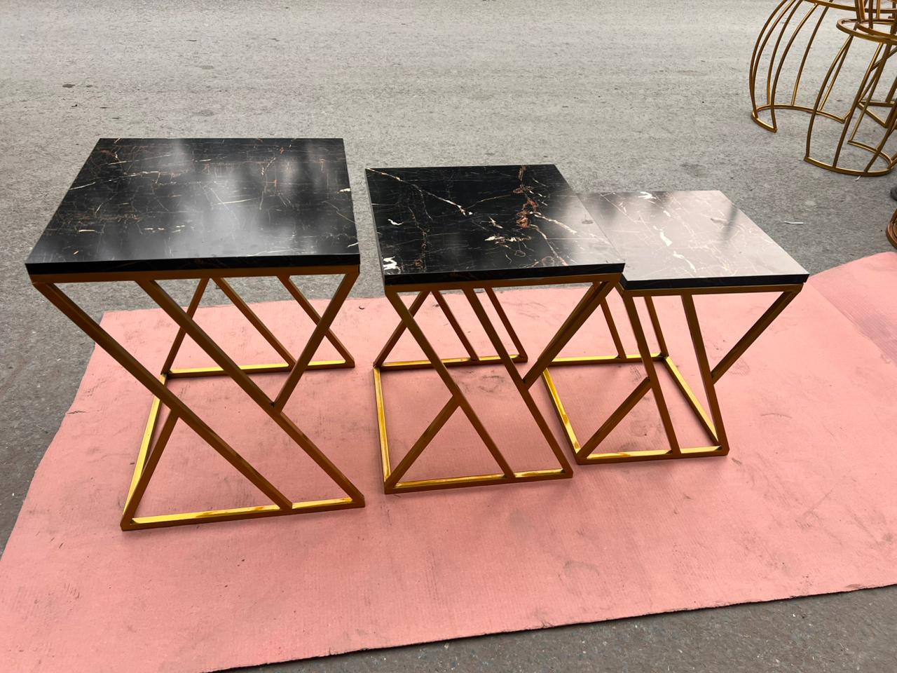 Set of two luxury marble nesting tables with gold zigzag metal frames, ideal as stylish side tables for living rooms.