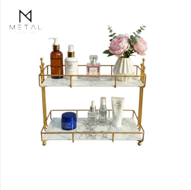 Gold and marble tray with skincare products and flowers on a white background